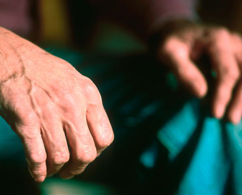 Photograph of old hands holding a teal napkin